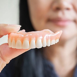 Woman holding dentures