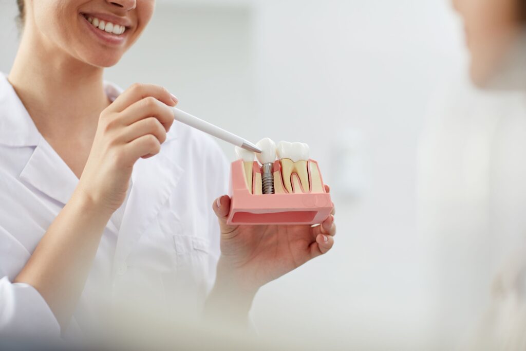 Dentist showing sample implant to patient